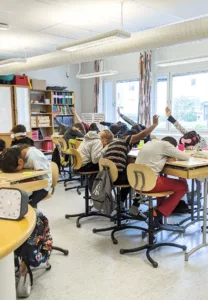 Elever räcker upp handen under omröstning.